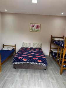 1 Schlafzimmer mit 2 Etagenbetten und einer Tagesdecke in der Unterkunft PousadaRR in Iupeba