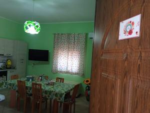 Un comedor con una mesa y una cocina. en Rainbow Apartment, en Scordia