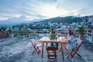 カリにあるHELICONIA Enjoy new comfortable studio apartment with terraceの二人の女性が座って市街の景色を望むテーブル