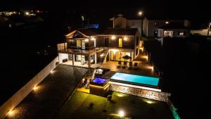 ノルデスチにあるCasa da Belavista with Jacuzziの夜間のスイミングプール付きの家の空中ビュー