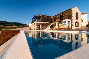 a swimming pool in front of a house at Casa da Belavista with Jacuzzi in Nordeste
