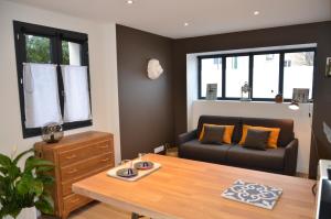 uma sala de estar com um sofá e uma mesa em Le Burlat - Studio - Lyon - Tassin em Tassin-la-Demi-Lune