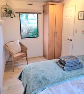 um quarto com uma cama, uma cadeira e uma janela em Badgers Rest Loddon em Norwich