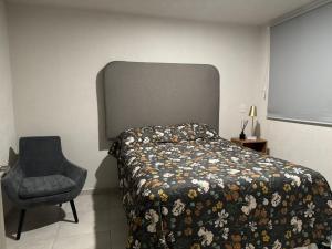 a bedroom with a bed and a chair at Depa cerca de todo GDL y Tlaq in Guadalajara