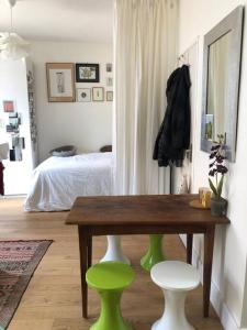 a room with a table and two green stools at Appartement calme et lumineux 4 voyageurs in Malakoff