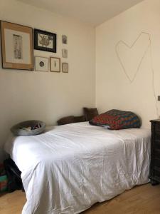 a bedroom with a white bed with a heart on the wall at Appartement calme et lumineux 4 voyageurs in Malakoff