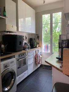 a kitchen with a washer and a washing machine at Appartement calme et lumineux 4 voyageurs in Malakoff