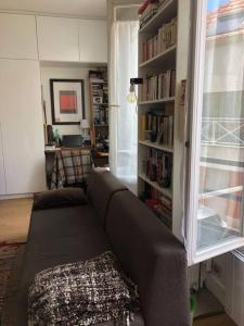 a living room with a couch and a book shelf at Appartement calme et lumineux 4 voyageurs in Malakoff