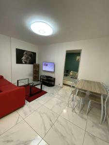 uma sala de estar com um sofá vermelho e uma televisão em Charmant appartement design em Blois
