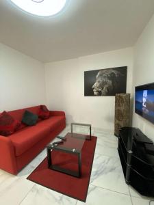 uma sala de estar com um sofá vermelho e uma mesa em Charmant appartement design em Blois