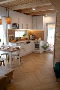 cocina con armarios blancos y suelo de madera en Pod Kalwarią, 