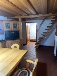una cocina con una mesa de madera y una escalera en Ferienhaus Almenland en Arzberg