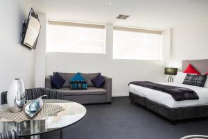 a hotel room with a bed and a couch at Adara Hotel Richmond in Melbourne