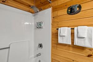 a bathroom with a shower and white towels at Laughing Bear Cabin 44B in Bryson City