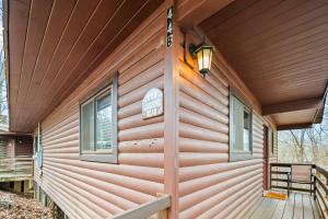 eine Hütte mit einer Holzwand mit Fenstern und einer Veranda in der Unterkunft Laughing Bear Cabin 44B in Bryson City