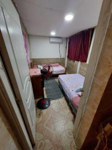 um pequeno quarto com duas camas e um candeeiro em Aatun Roof Flat in Haram elevator and two floors stairs no Cairo