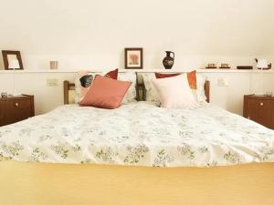 un letto con piumone bianco e cuscini sopra di Villa Anna a San Venanzo