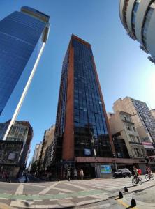 un edificio alto en una calle de la ciudad con edificios en Obelisco Sunset Apart 820 en Buenos Aires