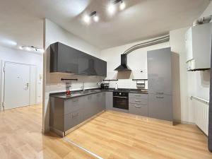 a large kitchen with stainless steel appliances and wooden floors at Clodia Skyline in Chioggia