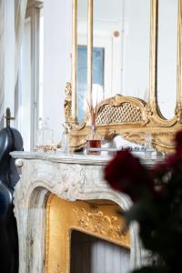 uma lareira dourada com um espelho em cima em Domus Tua em Modena