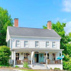 una casa blanca con una puerta azul en Marston House Wiscasset en Wiscasset