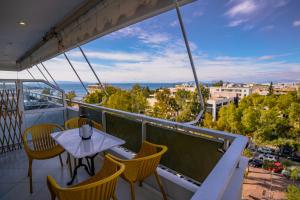 uma varanda com uma mesa e cadeiras e uma vista em Blue vibes by Glyfada beach em Atenas