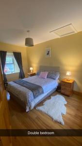 a bedroom with a bed and a window and a rug at Cheerful 3 bedroom country farm house in Ennis