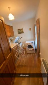 a kitchen with two stools and a washing machine at Cheerful 3 bedroom country farm house in Ennis
