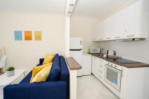 a living room with a blue couch in a kitchen at Blue vibes by Glyfada beach in Athens