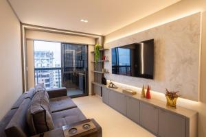 a living room with a couch and a large window at Park Del Prado #602 - Intermares por Carpediem in João Pessoa