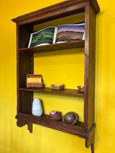 a wooden shelf with books and eggs on a yellow wall at Albero Mago in Florence