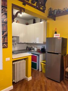 eine Küche mit gelben Wänden und einem Kühlschrank aus Edelstahl in der Unterkunft Albero Mago in Florenz