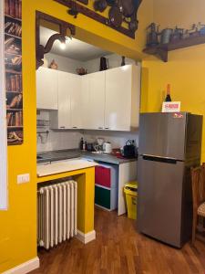 a kitchen with yellow walls and a stainless steel refrigerator at Albero Mago in Florence