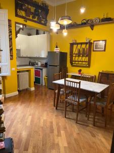 eine Küche mit gelben Wänden sowie einem Tisch und Stühlen in der Unterkunft Albero Mago in Florenz