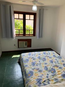 sypialnia z łóżkiem w pokoju z oknem w obiekcie Hospede-se em uma fabulosa casa de temporada em Búzios com 03 quartos! w mieście Búzios