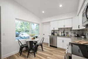 a kitchen with white cabinets and a table with chairs at Renovated Flat near Historic 25th Street, 2BR 1BA in Ogden