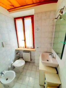La salle de bains est pourvue de toilettes, d'un lavabo et d'un miroir. dans l'établissement CIELO TERRA LUNA NUMANA, à Numana