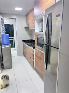 una cocina con un perro sentado en el suelo en Apartamento vista ao mar en São Luís