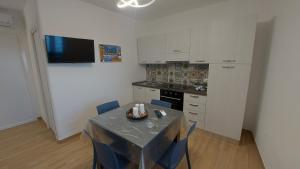 a kitchen with a table and blue chairs in a room at Marina House in Cefalù