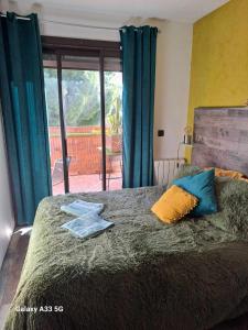 um quarto com uma cama com cortinas azuis e uma janela em chambre appartement terrasse em Fréjus