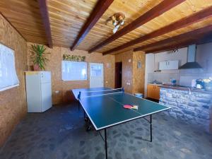 a ping pong table in a room with a kitchen at Pension Paunasul in Buşteni