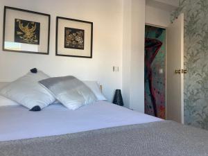 een slaapkamer met een wit bed met 2 kussens bij Yara Sobre Los Tejados de San Basilio in Córdoba +10 foto's