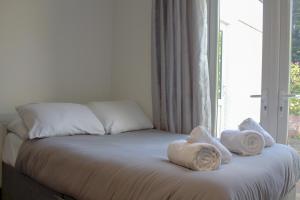 a bed with towels on it with a window at Double Modern Studio London in London