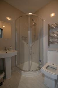 a bathroom with a shower and a toilet and a sink at Double Modern Studio London in London