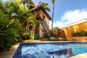 a house with a swimming pool in front of a house at Pousada Aconchego da Pipa in Pipa