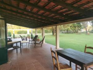 un patio coperto con tavoli, sedie e un campo di T1 na Casa da Quinta S José a Praia de Mira