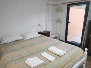 um quarto com uma cama com duas toalhas em T1 na Casa da Quinta S José na Praia de Mira
