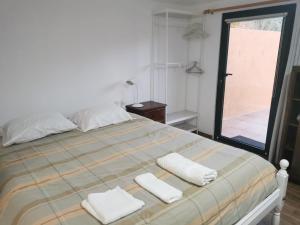 una camera da letto con un letto con due asciugamani sopra di T1 na Casa da Quinta S José a Praia de Mira