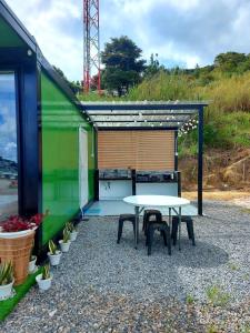 einen Tisch und Stühle auf einer Terrasse mit einem grünen Gebäude in der Unterkunft SF Homestay in Kampong Kundassan
