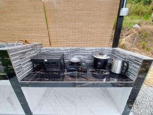 a glass table with two pots and pans on it at SF Homestay in Kampong Kundassan